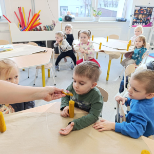 Zabawy sensoryczne - dotykamy i rolujemy woskowe świece, wąchamy aromat ziół i  smakujemy miód. Autor Alicja Murawka